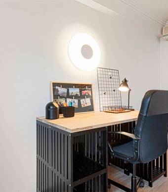Criar uma secretaria num quarto com parede branca e pavimento laminado, candeeiro de parede e utensílios de decoração 